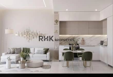 Monolocale in vendita a Dubai Land Residence Complex (DLRC), Dubai - Modern open-plan living and dining area with marble kitchen, sage green chairs, and neutral tones in Dubai apartment