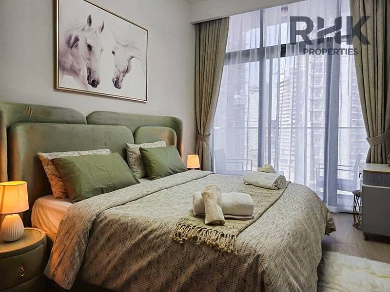 2 Furnished bedroom with green velvet headboard in 1-bedroom apartment for rent in Azizi Riviera 41, MBR City