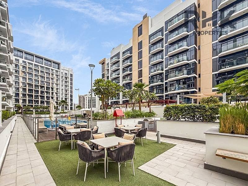8 Outdoor terrace with BBQ seating and pool at Azizi Riviera 41 podium level, Meydan Dubai