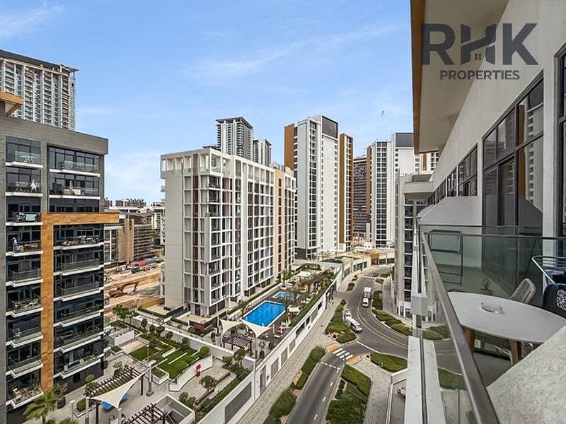 9 Balcony view over Azizi Riviera community pool and mid-rise towers from apartment in MBR City Dubai