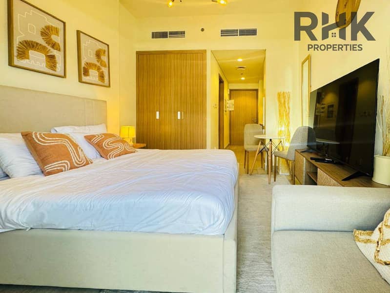 2 Furnished studio interior with king bed, sofa and smart TV in a Dubai serviced apartment
