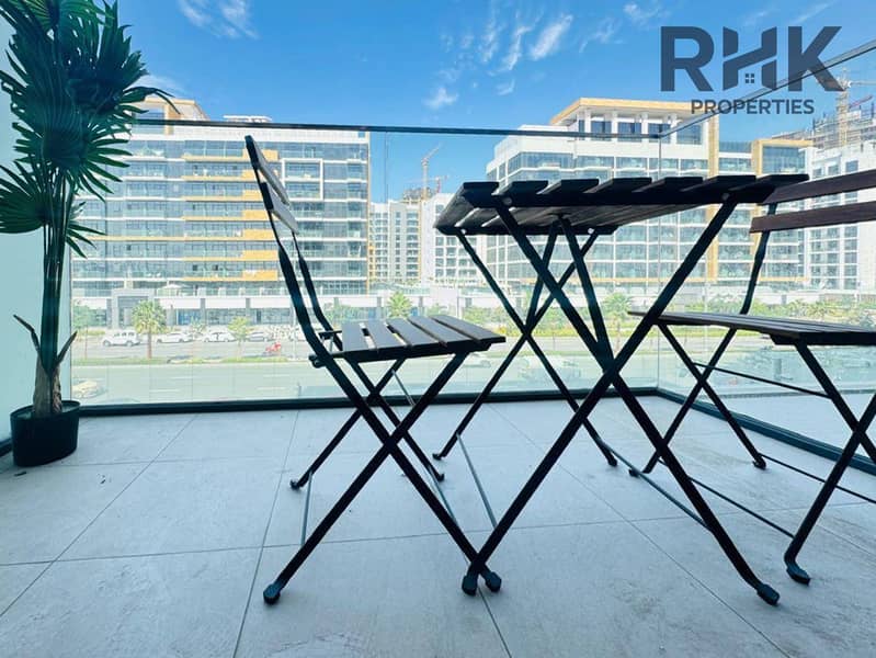4 Furnished apartment balcony with bistro set and city view of low-rise Dubai residential towers