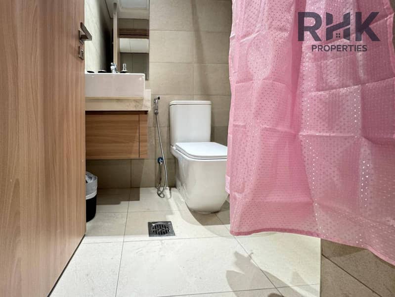 5 Modern bathroom with wall-hung vanity, mirror and walk-in shower in a furnished Dubai studio