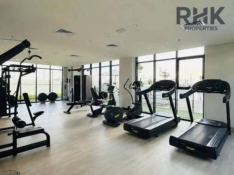 7 Fully-equipped residents' gym with treadmills and Technogym equipment overlooking the pool in Dubai