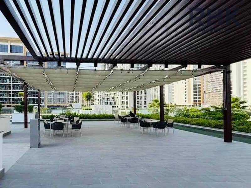 8 Shaded rooftop terrace lounge with pergola and seating at a Dubai apartment building