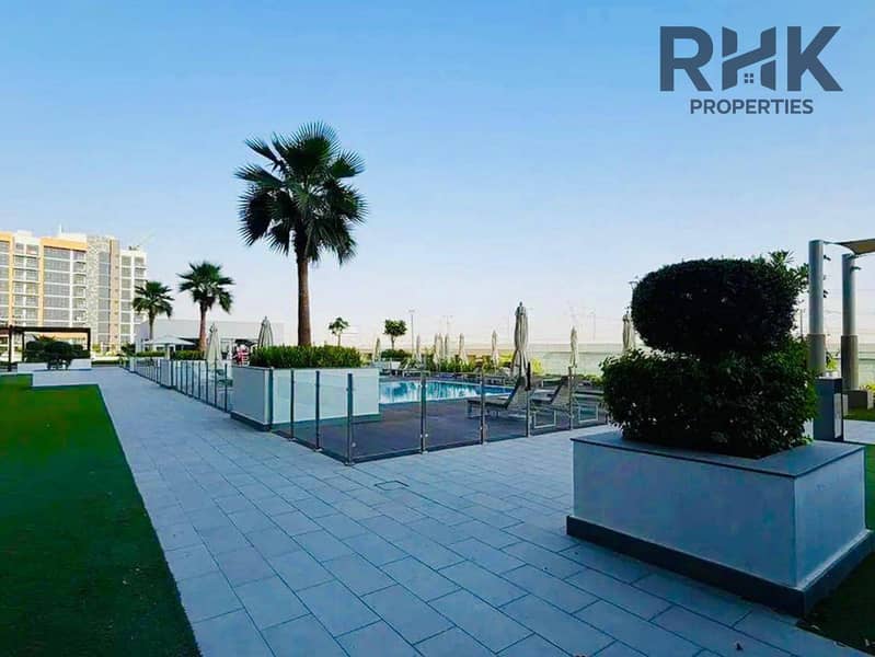 10 Landscaped pool deck with palm trees and sun loungers at a Dubai residential apartment community
