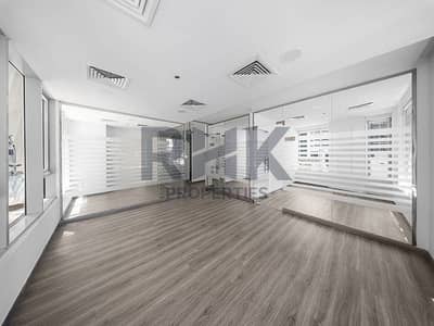 Office in affitto a Business Bay, Dubai - Fitted office for rent in Ontario Tower Business Bay with glass-partitioned rooms, wood-look flooring and city tower views through frosted panels