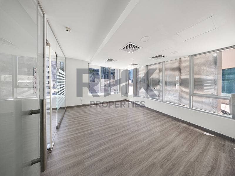 4 Bright corner office room in Ontario Tower Business Bay with floor-to-ceiling windows, glass door and laminate wood flooring for rent