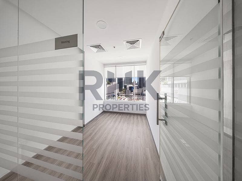 5 Glass-partitioned meeting room in Ontario Tower Business Bay office with tower views, frosted stripe glazing and wood-look laminate floors