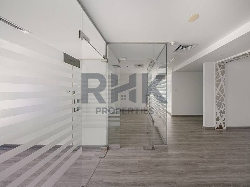 7 Modern partitioned office in Ontario Tower Business Bay with meeting room, decorative feature column and grey wood-effect flooring