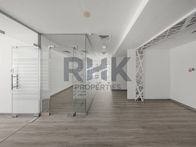 8 Open-plan fitted office in Ontario Tower Business Bay with glass partition walls, artistic column screen and laminate wood flooring