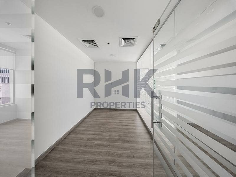 19 Partitioned office hallway in Ontario Tower Business Bay with glass door, striped frosted glazing and grey wood-effect flooring