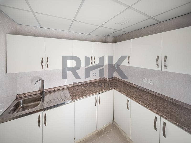 24 Office kitchen pantry in Ontario Tower Business Bay with L-shaped cabinets, granite worktop and stainless sink in a fitted workspace