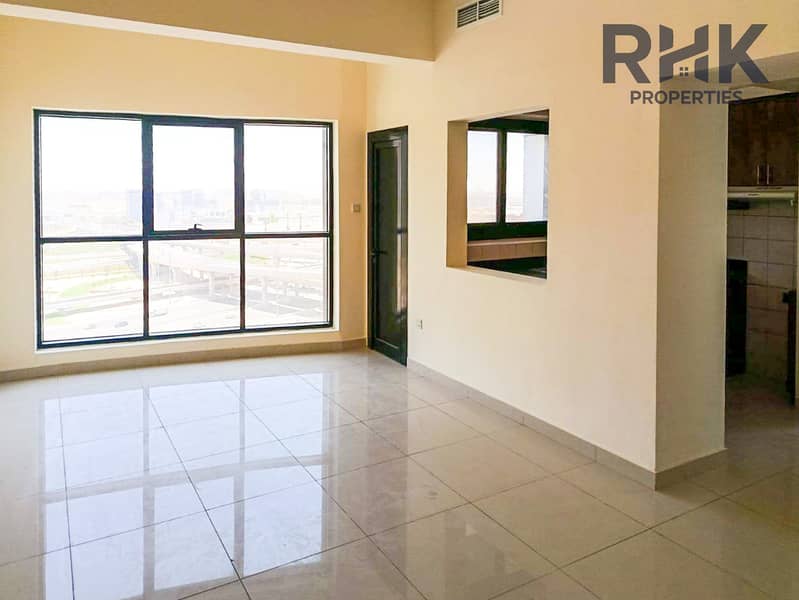 3 Bright living room with balcony views and open kitchen hatch in JLT Dubai apartment