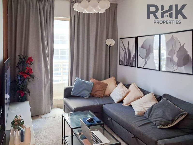 2 Furnished livinGrey L-shaped sofa and wall art in Dubai Marina furnished apartment loungeg room with grey sofa and balcony access, Dubai Marina apartment