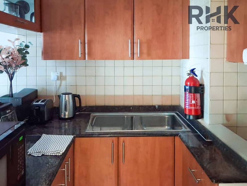 9 Open kitchen breakfast bar with stools beside living area, Dubai Marina apartment