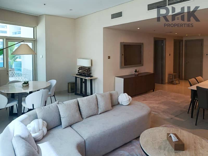 2 Furnished living room with curved sofa and marble dining table in Dubai Marina apartment for sale