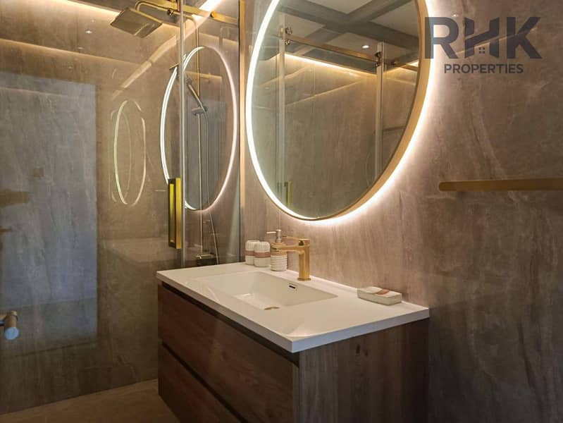 10 En-suite bathroom with backlit mirror, gold tapware and walk-in shower in Marina apartment