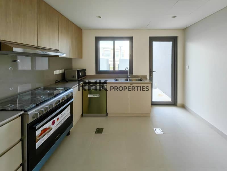 5 Modern kitchen with Bosch gas range, dishwasher, wood upper cabinets and grey backsplash in Dubai townhouse