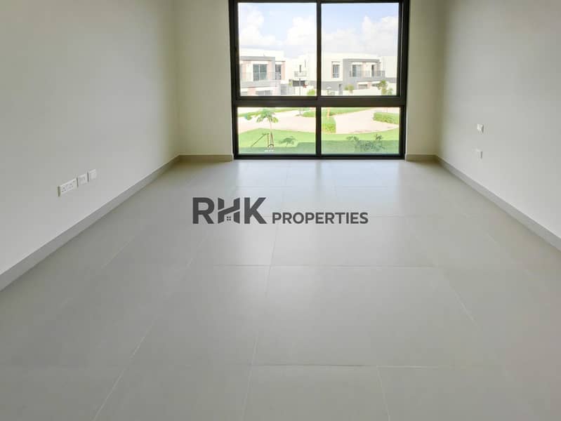 6 Bright bedroom with floor-to-ceiling windows overlooking landscaped community park in Dubai