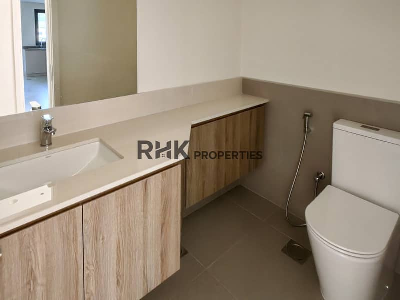 10 Modern bathroom vanity with wood cabinets, quartz countertop and wall-mounted toilet in Dubai townhouse