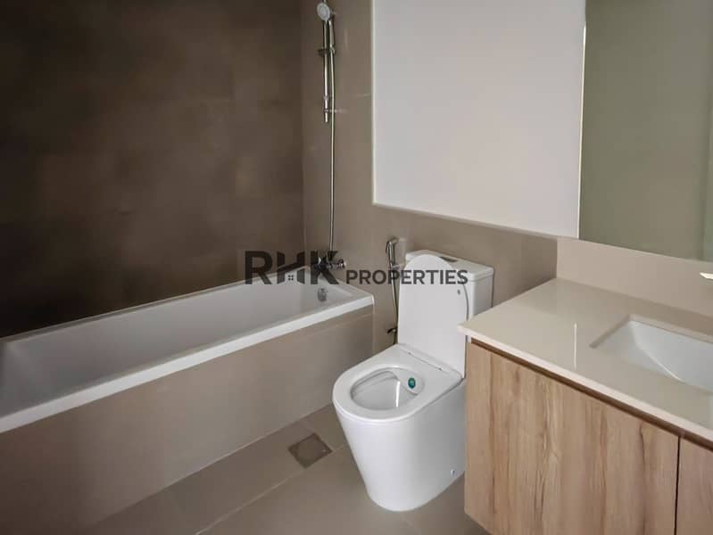 13 En-suite bathroom with soaking tub, toilet and wood vanity unit in Dubai residential townhouse