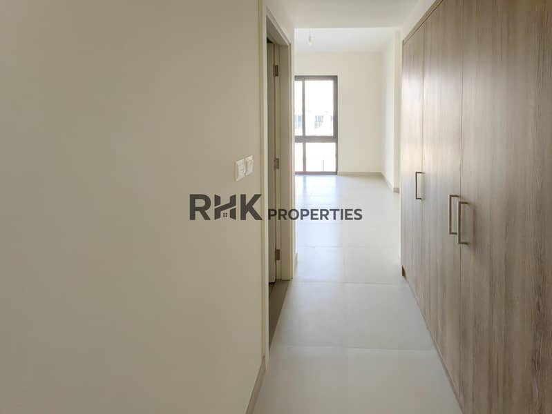 24 Bright bedroom hallway with built-in wood wardrobe and balcony window view in Dubai townhouse