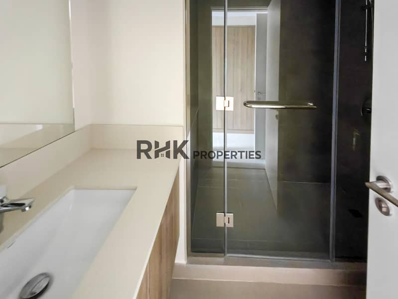 28 Master en-suite bathroom with glass shower enclosure, quartz vanity and dark tile walls in Dubai townhouse