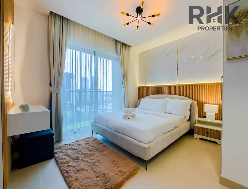 2 Master bedroom with king bed, fluted wood headboard and marble accent wall in Dubai Creek Harbour apartment