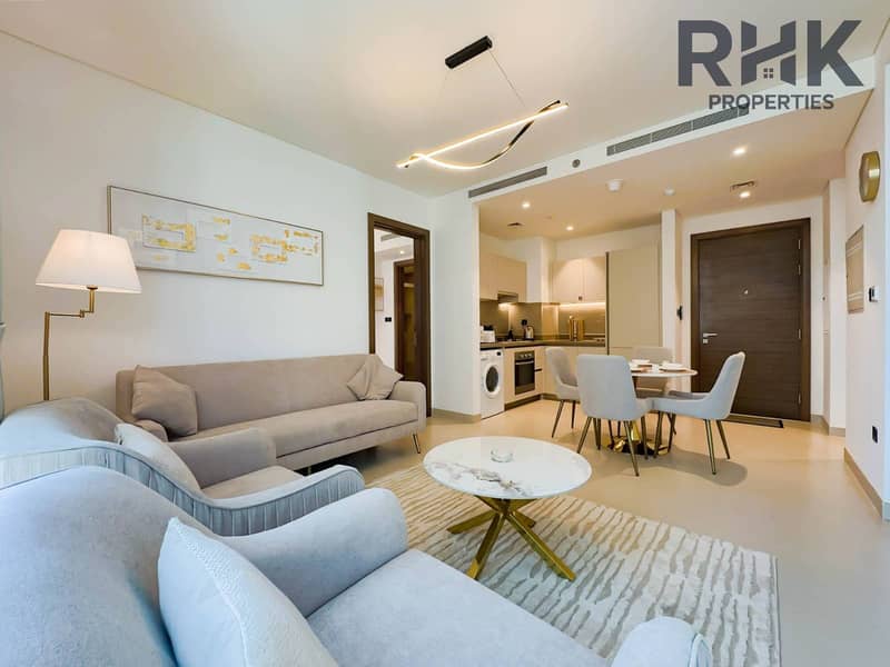4 Open-plan living, dining and kitchen area with washer and modern finishes in furnished Dubai apartment