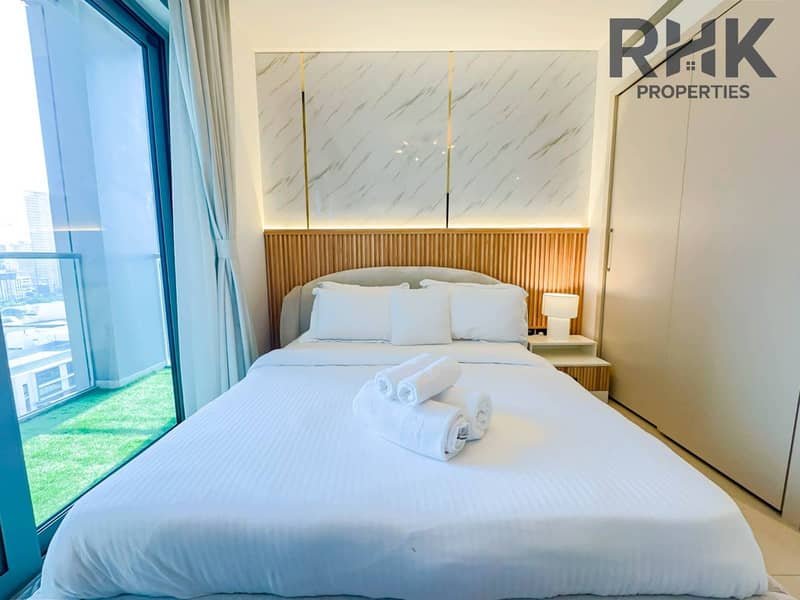 7 Furnished bedroom with built-in wardrobe, marble headboard wall and balcony access in Dubai apartment