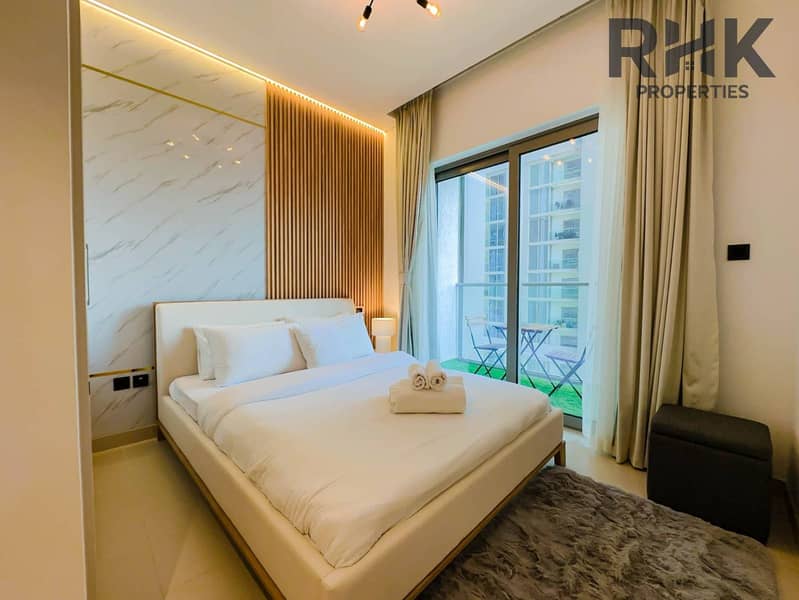 8 Cozy bedroom with sliding wardrobe and wood-panelled feature wall in furnished Dubai residence
