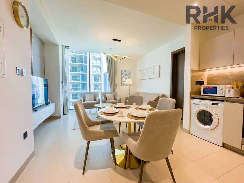 10 Dining table for six beside fully-equipped kitchen and lounge in Dubai Creek Harbour apartment