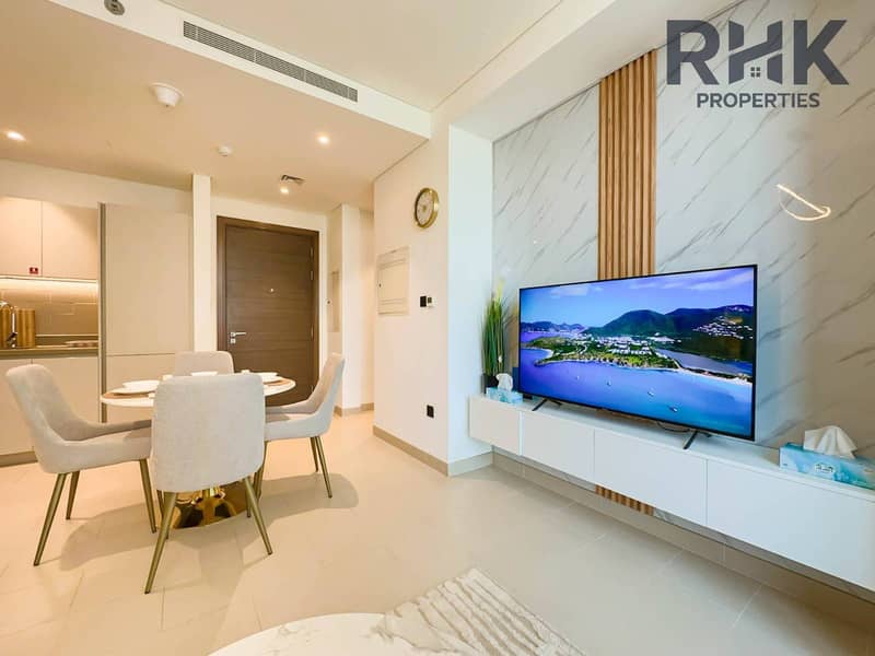 11 Dining area with smart TV and marble media wall in modern Dubai Creek Harbour apartment
