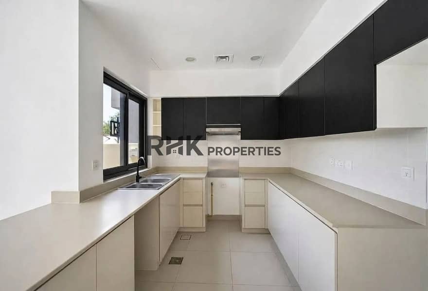 6 U-shaped kitchen with dark overhead cabinets, built-in oven and double sink in Dubai villa