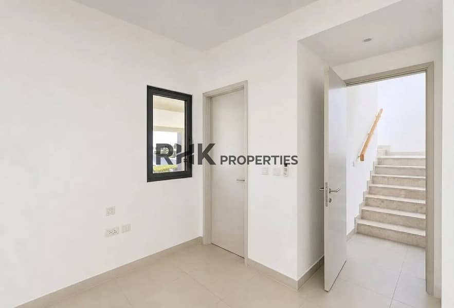 10 Bright ground-floor bedroom with built-in wardrobe and staircase access in Dubai townhouse