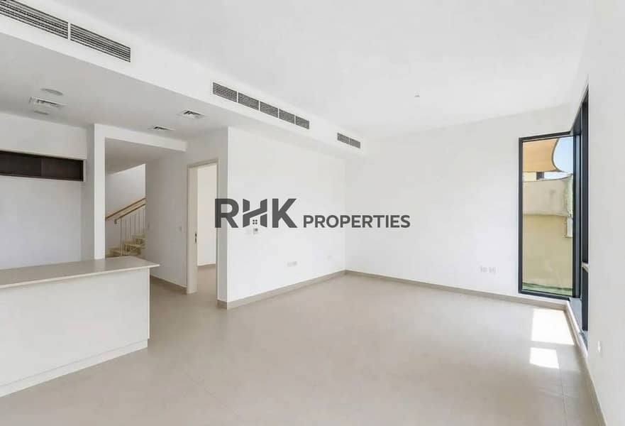 4 Bright living room with staircase, central AC vents and side window in Dubai townhouse
