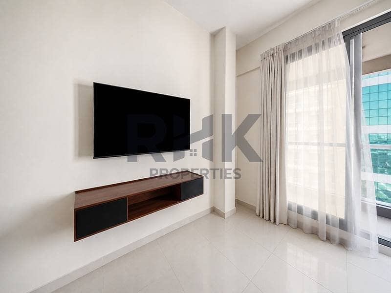 8 Living room with wall-mounted TV and balcony access in Marina apartment