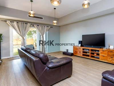 2 habitaciones Villa para en Venta en Arabian Ranches, Dubai - Spacious living room with dark leather sofa, large TV, and garden sliding door 2 habitaciones Villa para en Venta en Arabian Ranches, Dubai - Spacious living room with dark leather sofa, large TV, and garden sliding door
