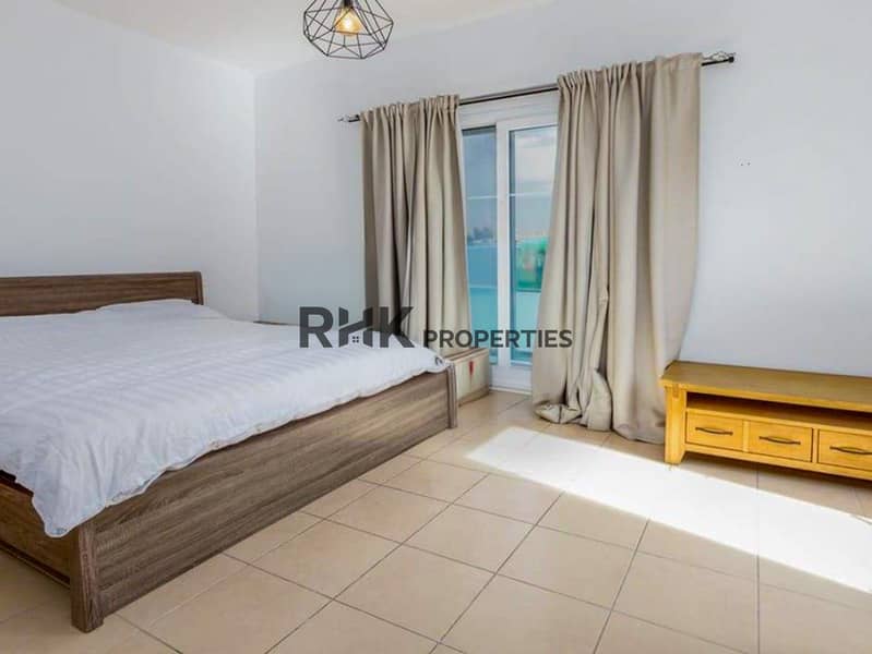 4 Bright secondary bedroom with double bed, balcony access, and wood-frame TV console