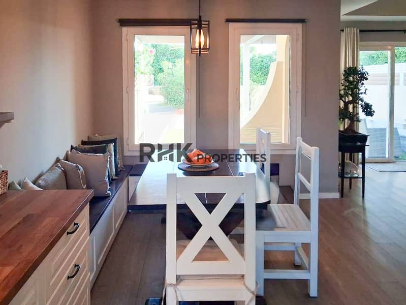 5 Cozy dining nook with built-in bench seating, dark wood table, and garden views
