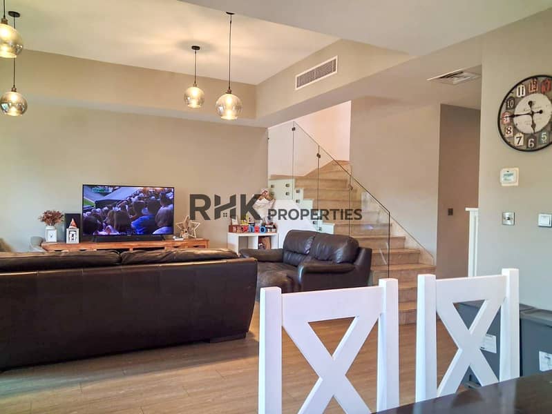 7 Open plan family room with pendant lights, glass staircase banister, and dining chairs