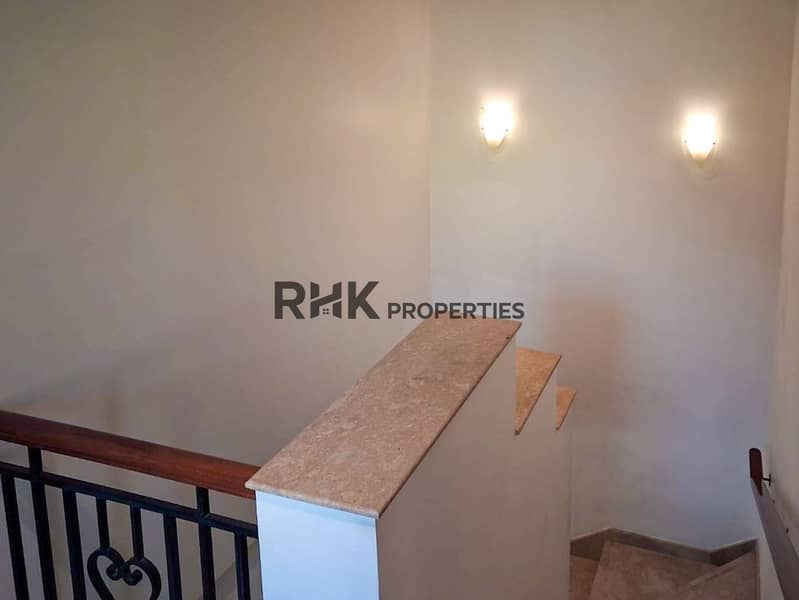 13 Upper floor landing with marble balustrade, wrought iron staircase, and wall sconces