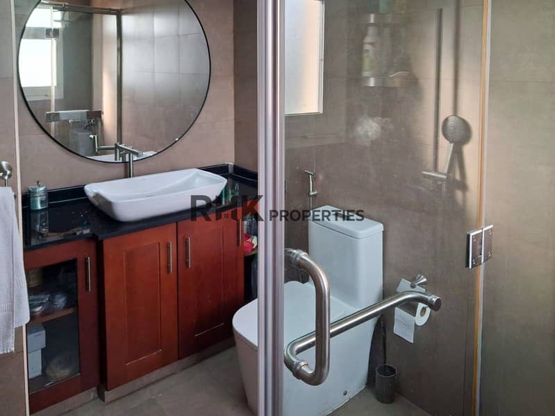 8 Modern en suite bathroom with vessel sink, round mirror, and glass shower enclosure
