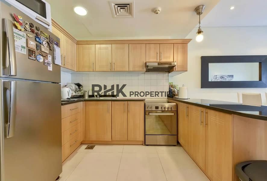 4 Fitted kitchen with wooden cabinets in a 2BR Yacht Bay apartment for rent in Dubai Marina