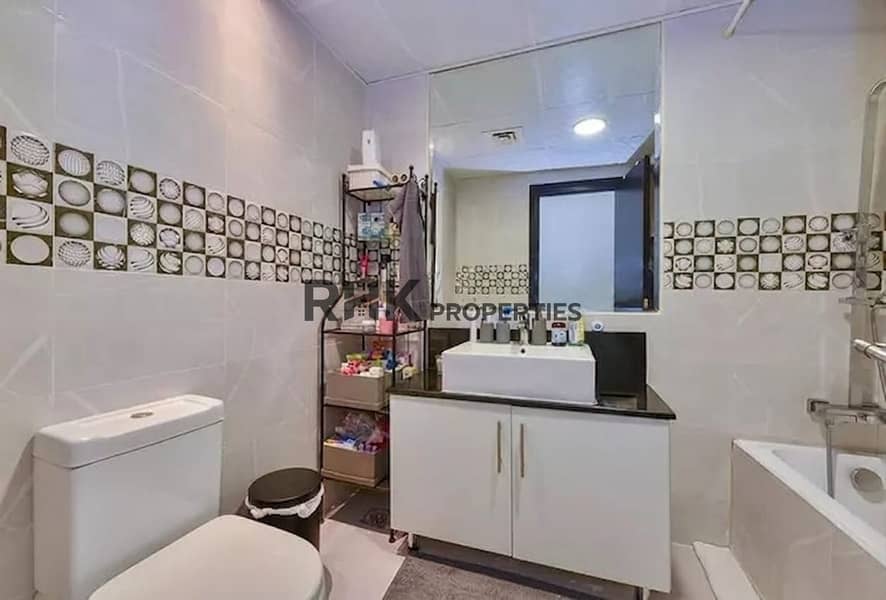 9 Modern bathroom with vanity and bathtub in a 2BR Yacht Bay apartment for rent