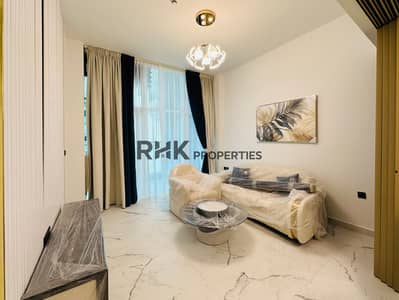 شقة 1 غرفة نوم للبيع في مجمع دبي للعلوم، دبي - Elegant furnished living room with cream sofa set, glass coffee table, floor-to-ceiling curtains, designer chandelier, and city view balcony in luxury Dubai apartment