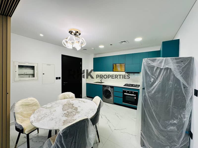 6 New fully equipped kitchen with teal L-shaped cabinetry, built-in microwave, gas cooktop, oven, washing machine, marble countertop, and under-cabinet LED lighting in Dubai residential apartment