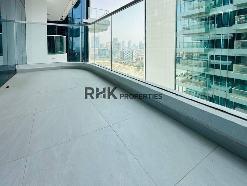 12 Spacious high-floor balcony with full-glass safety railing, panoramic Dubai urban skyline view, and premium tiled outdoor flooring in luxury apartment for sale or rent in Dubai