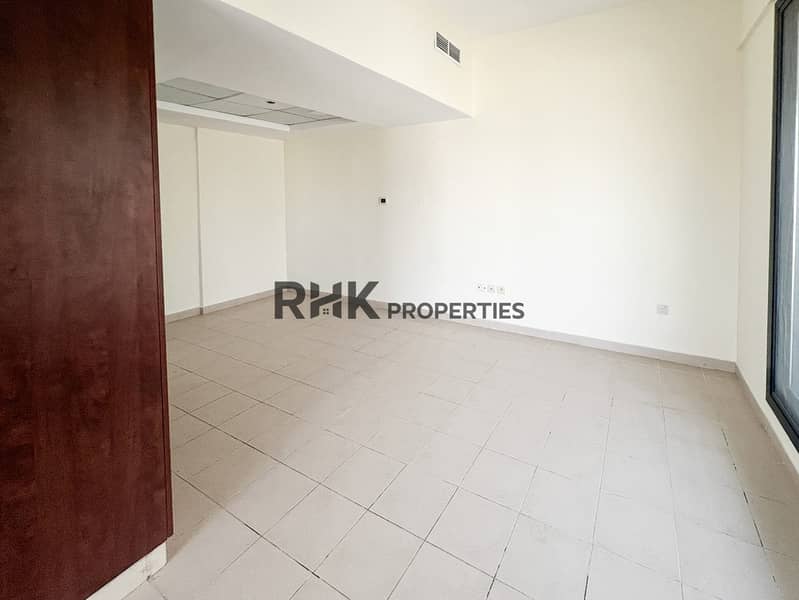 3 Open-plan living area with matte ceiling feature and tiled floor in unfurnished Dubai apartment